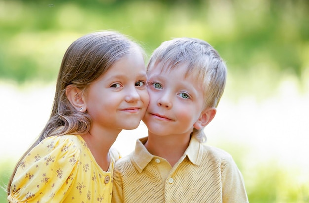 les enfants posent devant la caméra, pressant leurs joues l'une contre l'autre