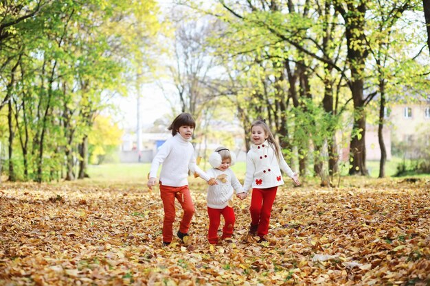 Enfants pour une promenade dans le parc d'automne Chute de feuilles dans le parc Bonheur d'automne en famille