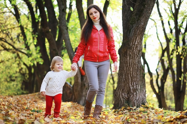 Enfants pour une promenade dans le parc en automne. Chute des feuilles dans le parc. Famille. Tomber. Joie.