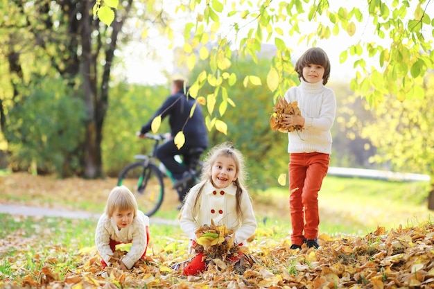 Enfants pour une promenade dans le parc en automne. Chute des feuilles dans le parc. Famille. Tomber. Joie.