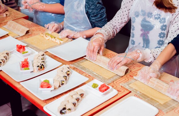 Les enfants préparent des sushis et des petits pains. Restaurant de maître.