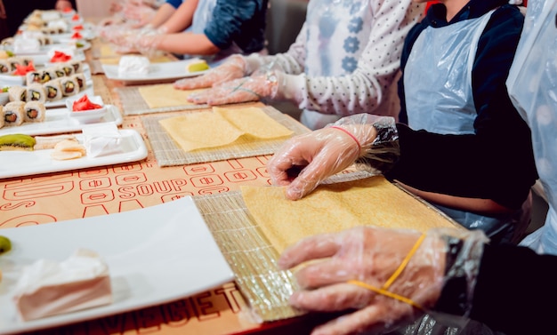 Les enfants préparent des sushis et des petits pains. Restaurant de maître.