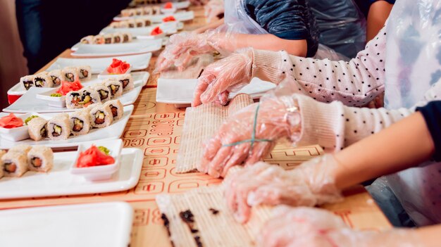 Les enfants préparent des sushis et des petits pains. Restaurant de maître.