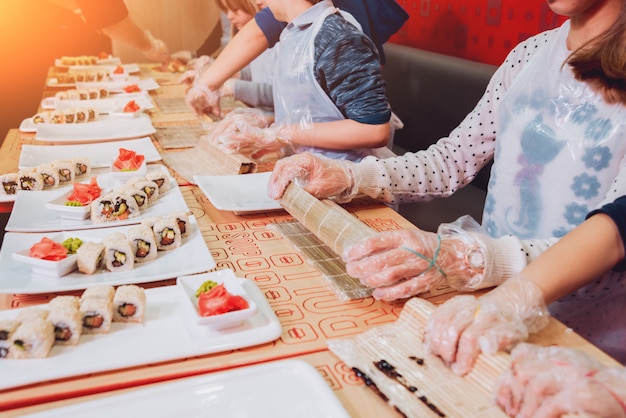 Les enfants préparent des sushis et des rouleaux. Restaurant de maître.