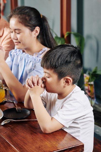 Enfants priant avant le dîner