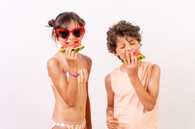 Enfants profitant de l'été en mangeant un concept de vacances scolaires à la pastèque Fond blanc
