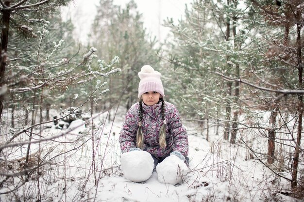 Les enfants profitent de la première neige dans la forêt d'hiver, des activités saisonnières actives, du style de vie