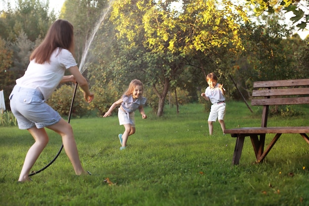 Photo enfants en promenade en été. les enfants s'adonnent à la campagne. rires et projections d'eau.