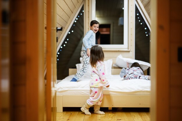 Enfants en pyjama doux et chaud jouant à la maison de la cabane en bois Concept de bonheur d'activité de loisirs de l'enfance Frère et sœurs s'amusant et jouant ensemble