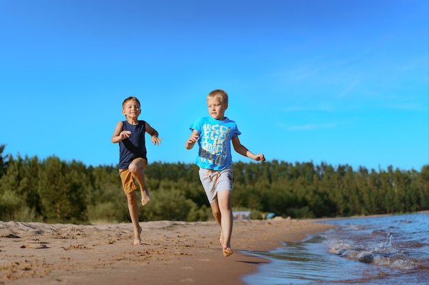 Enfants qui courent seuls sur la plage. coucher de soleil et ciel bleu. Concept d'enfance heureuse. photo de haute qualité