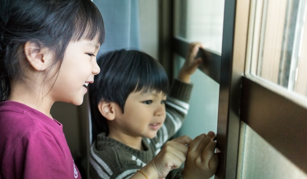 enfants regardant par la fenêtre