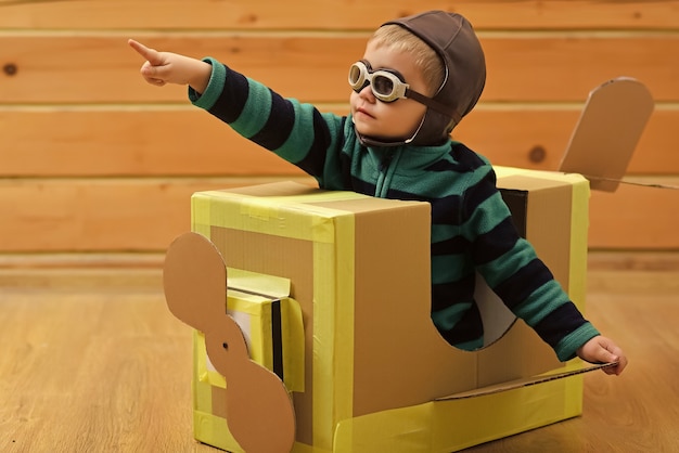 Les enfants rêvent. Petit garçon enfant joue dans un avion en carton, enfance.