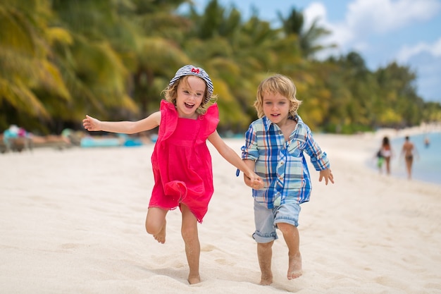 Enfants s'amusant à courir ensemble sur la plage