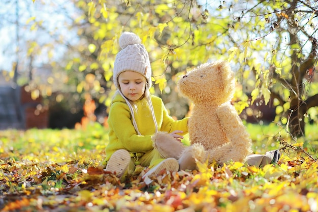 Enfants s'amusant et s'équilibrant sur l'arbre dans les bois d'automne