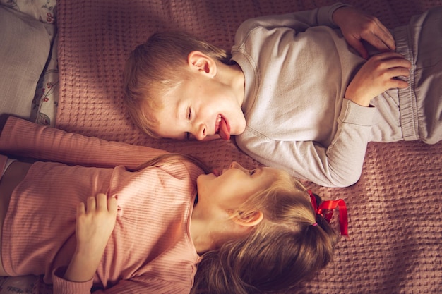 Les enfants s'amusent au lit. Crépuscule, heure de sommeil.