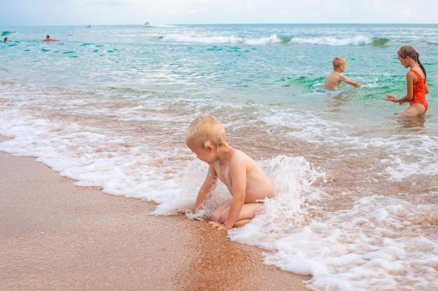 Les enfants s'amusent et jouent dans la vague de la mer Vacances d'été en famille sur la côte de la mer
