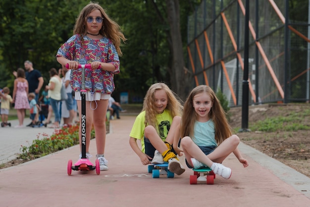 les enfants s'amusent sur un scooter et une planche à roulettes