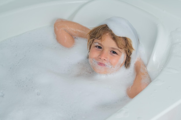 Enfants se baignant enfant se baignant dans un bain avec de la mousse visage drôle d'enfant baigné dans le bain