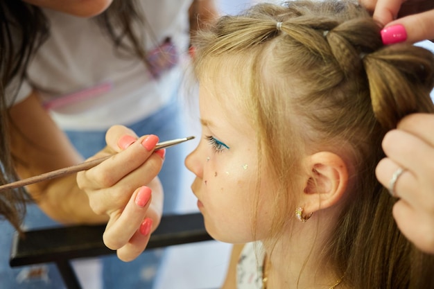 Les enfants se maquillent Maquillage scintillant Scintille sur la joue