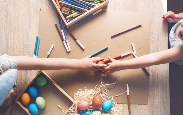 Les enfants se préparent pour les enfants de pâques peignant des oeufs de pâques