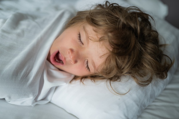 Les enfants se réveillent le matin. Portrait en gros plan d'un enfant endormi.