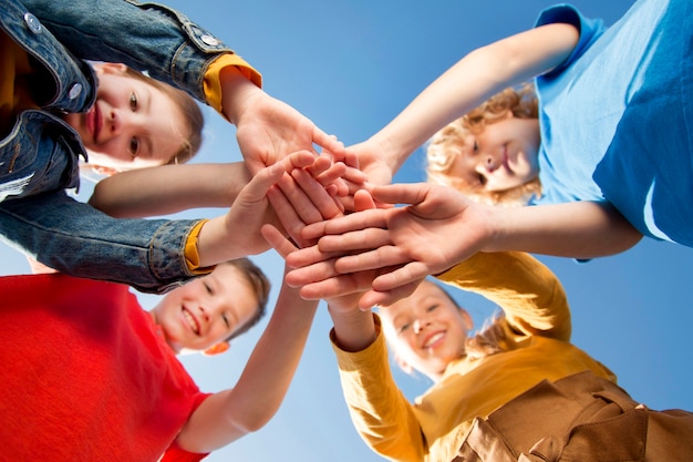 Photo enfants se tenant la main en équipe se bouchent