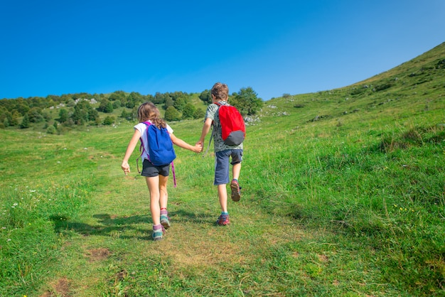 Les enfants se tiennent la main lors d'une randonnée dans les montagnes