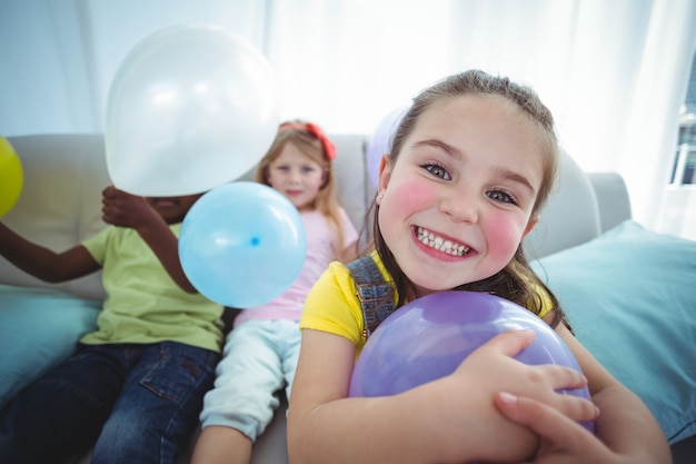 Enfants souriants jouant avec des ballons