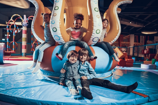 Enfants souriants mignons sur une aire de jeux intérieure moderne