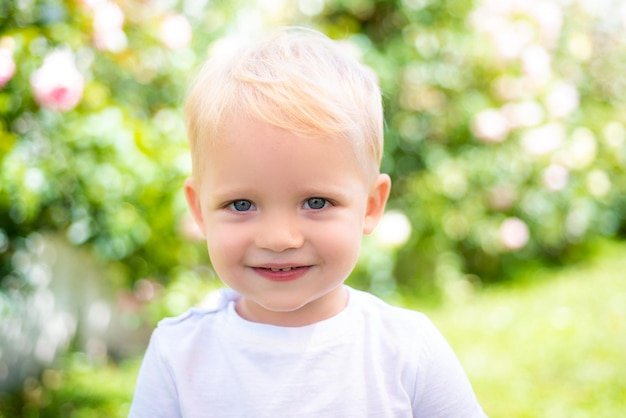 Les enfants souriants mignons font face à un portrait en gros plan d'un garçon enfant souriant sur fond flou