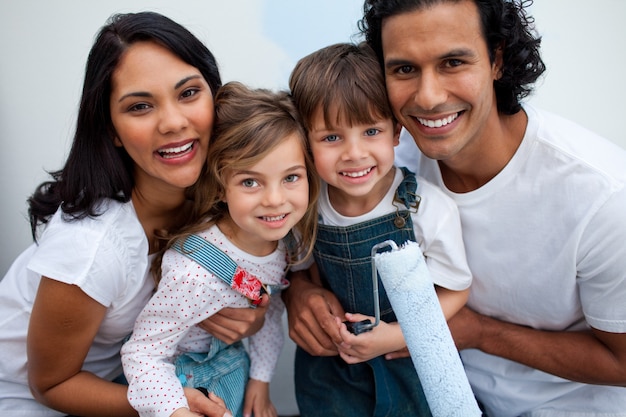 Enfants souriants peignant une chambre avec leurs parents