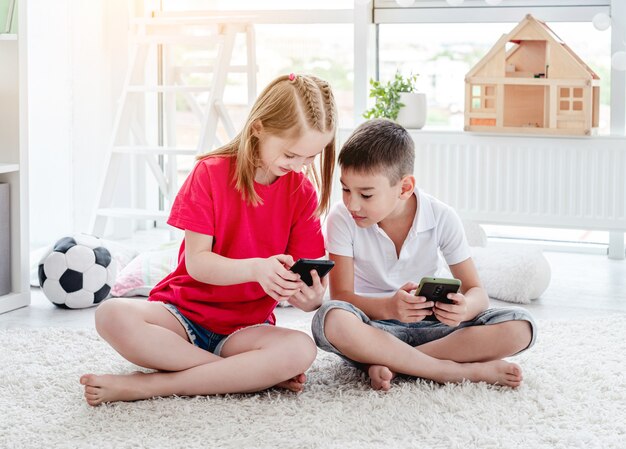 Enfants souriants regardant smartphone