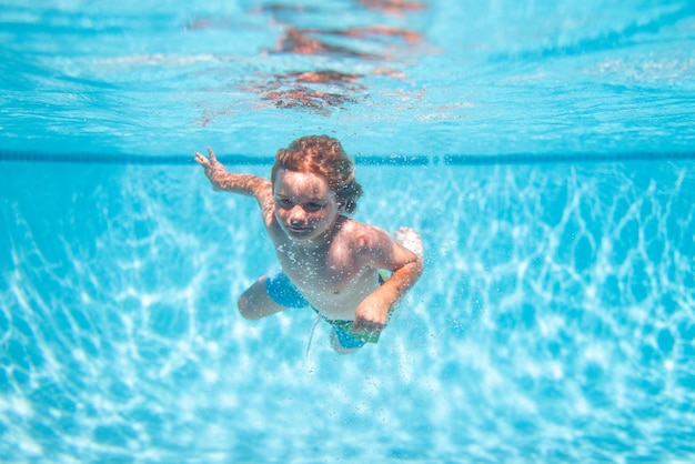 Les enfants sous-marins nagent dans la piscine enfant en bonne santé nageant et s'amusant sous l'eau