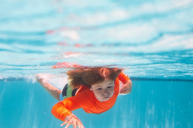 Les enfants sous-marins nagent dans la piscine enfant en bonne santé nageant et s'amusant sous l'eau