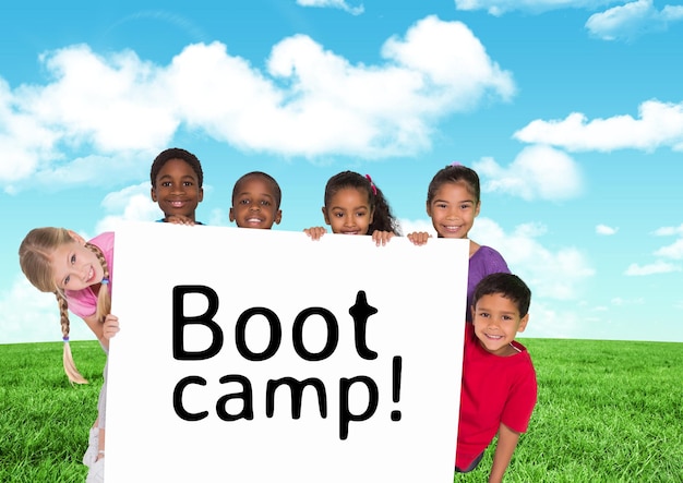 Enfants tenant une carte montrant un camp d'entraînement de texte devant un ciel bleu et de l'herbe