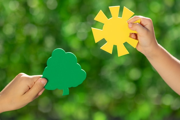 Enfants tenant une jeune plante verte dans les mains.