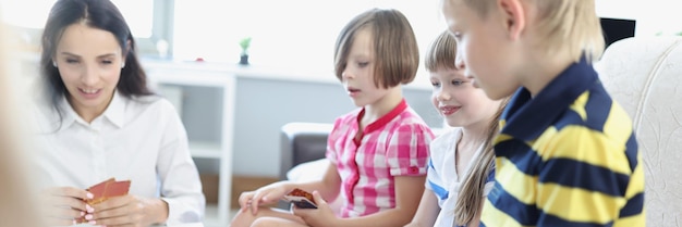 Les enfants tiennent un jeu de cartes à jouer avec les parents à des jeux à la maison pour le développement