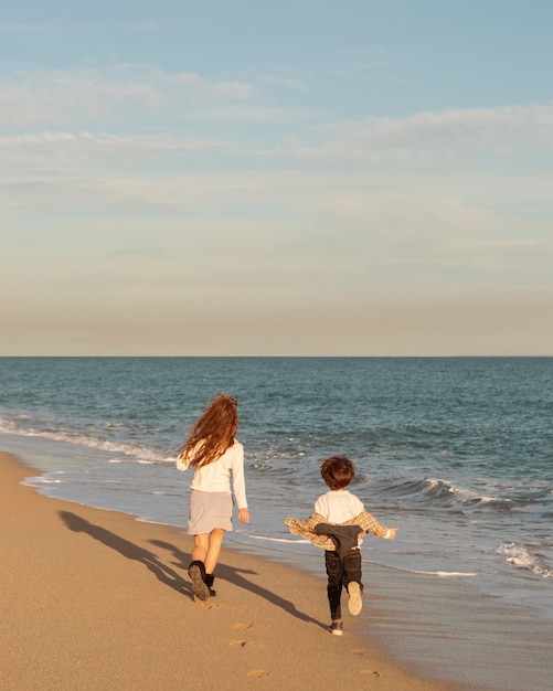 Photo enfants de tir complet en cours d'exécution sur le rivage