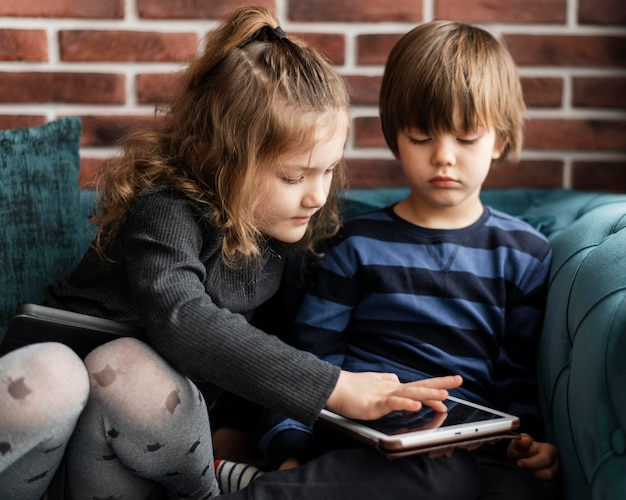 Enfants tir moyen assis sur un canapé