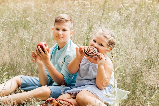 Enfants en train de déjeuner à l'extérieur Enfants en pique-nique dans le jardin de printemps