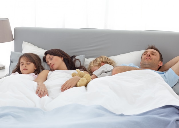 Enfants tranquilles dormant avec leurs parents