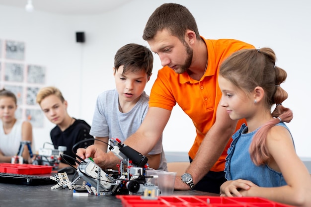 Enfants travaillant avec un enseignant sur leur projet d'éducation aux robots