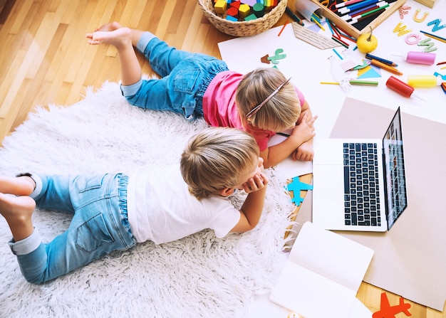 Enfants utilisant la technologie informatique en ligne pour dessiner ou faire de l'artisanat