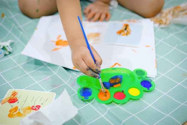 Les enfants utilisent des pinceaux aquarelle pour créer de l'imagination et améliorer leurs compétences d'apprentissage.