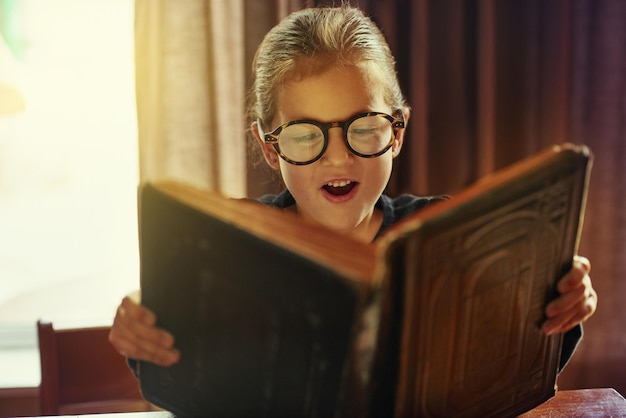 Les enfants voient la magie parce qu'ils la recherchent Photo recadrée d'une petite fille lisant un livre magique