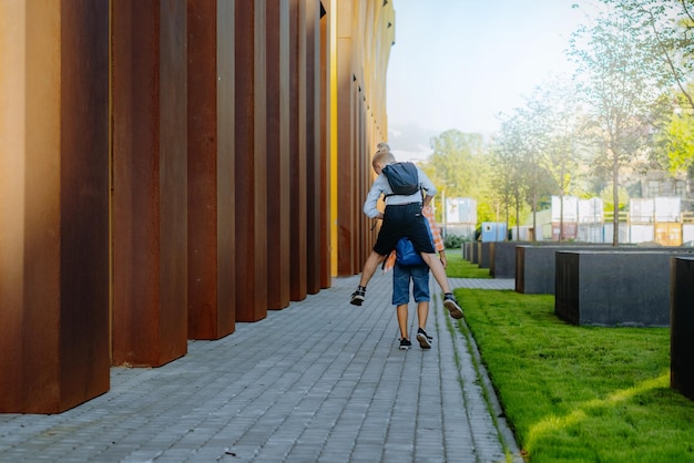 les enfants vont à l'école avec des sacs à dos par temps ensoleillé. Début d'année universitaire. Image avec mise au point sélective