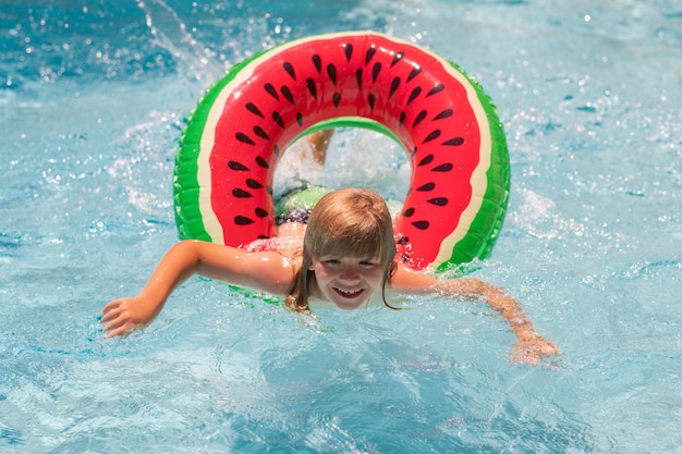 Les enfants de voyage d'été nagent avec un anneau flottant pendant les vacances d'été