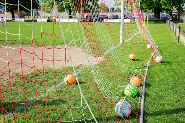 Engrenages de football sur l'herbe verte préparés pour l'entraînement dans l'académie de football pour enfants Activité sportive populaire