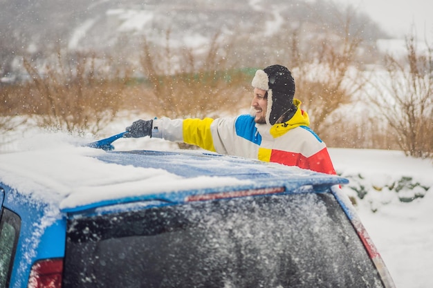 Enlever la neige de la voiture avec une brosse