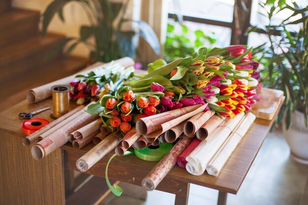 Un énorme bouquet de tulipes multicolores se trouve sur une table dans un magasin de fleurs